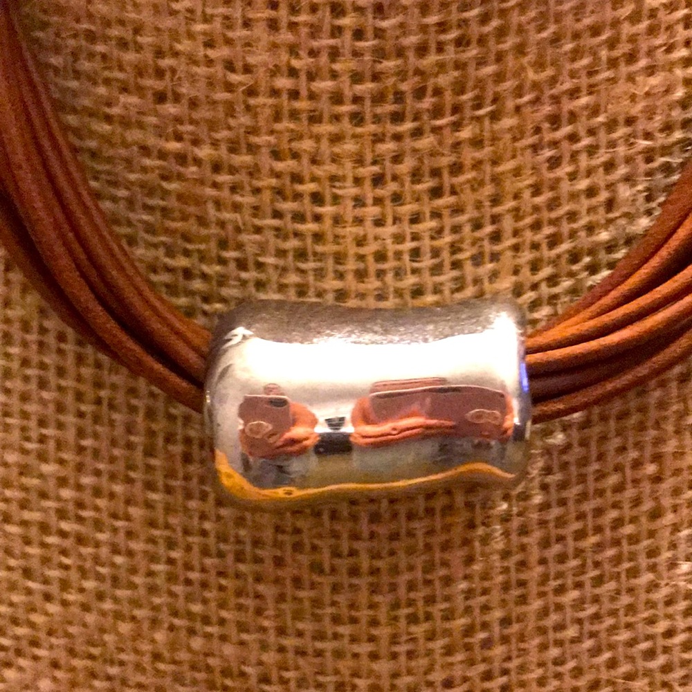 Brown leather choker with silver pendant.
